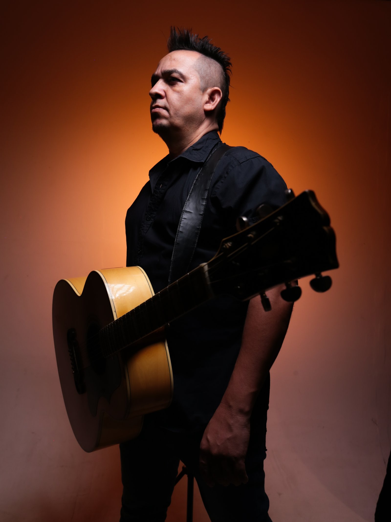 Sujeito Rock com violão no ombro